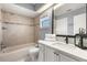 Updated bathroom features a shower-tub combination with neutral tile and an updated vanity with marble countertop at 2566 Conway Gardens Rd, Orlando, FL 32806