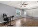 Bedroom features hardwood flooring, ceiling fan, and a modern glass wall, creating a tranquil space at 2566 Conway Gardens Rd, Orlando, FL 32806
