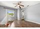 Bright bedroom featuring hardwood flooring, ceiling fan, and en-suite bathroom access at 2566 Conway Gardens Rd, Orlando, FL 32806