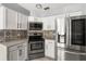 Bright kitchen featuring stainless steel appliances, white cabinets, and decorative tile backsplash at 2566 Conway Gardens Rd, Orlando, FL 32806