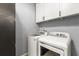 A laundry room with a white washer and dryer, grey walls and white cabinetry at 2566 Conway Gardens Rd, Orlando, FL 32806