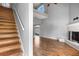 Staircase leading to the living room with soaring ceilings, fireplace, and hardwood floors at 2566 Conway Gardens Rd, Orlando, FL 32806
