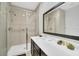 Well-lit bathroom with a shower featuring a glass enclosure and a single sink vanity at 2619 Corvette Ln, Kissimmee, FL 34746