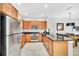 Modern kitchen with stainless steel appliances, wooden cabinets, granite countertops, and an adjacent dining area at 2619 Corvette Ln, Kissimmee, FL 34746