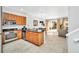 Bright, modern kitchen with stainless steel appliances, granite countertops, wooden cabinets, and an open dining area at 2619 Corvette Ln, Kissimmee, FL 34746