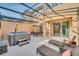 A screened-in patio featuring a hot tub, lounge chairs, and a dining table at 2619 Corvette Ln, Kissimmee, FL 34746