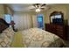 Comfortable bedroom featuring a large patterned bed, a ceiling fan, and a dresser with a mirror at 2677 Emerald Island Blvd, Kissimmee, FL 34747