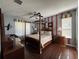 Spacious main bedroom features a four-poster bed, wood floors, and ample natural light at 2677 Emerald Island Blvd, Kissimmee, FL 34747