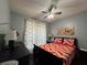 Cozy bedroom with a ceiling fan, patterned curtains, and decorative artwork at 2677 Emerald Island Blvd, Kissimmee, FL 34747