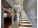 Welcoming foyer featuring an open staircase and views of the dining and living areas at 2677 Emerald Island Blvd, Kissimmee, FL 34747