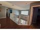 Bright hallway features hardwood flooring, white railings, and ample natural light at 2677 Emerald Island Blvd, Kissimmee, FL 34747