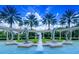 Community water fountain featuring dolphin statues with palm trees and a clear blue sky in the background at 2677 Emerald Island Blvd, Kissimmee, FL 34747