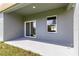 An outdoor covered porch with light gray concrete and a sliding glass door entrance to the home at 2700 Sw 162Nd St Rd, Ocala, FL 34473