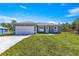 Charming single-story home featuring a manicured lawn, two-car garage, and a light gray stucco finish at 2700 Sw 162Nd St Rd, Ocala, FL 34473
