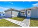 A modern single-story home with a two-car garage, a green lawn, and light gray stucco at 2700 Sw 162Nd St Rd, Ocala, FL 34473