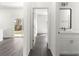 Bright hallway featuring wood-style floors, leading to a modern bathroom with a white vanity at 2700 Sw 162Nd St Rd, Ocala, FL 34473