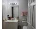 Well-lit bathroom with a vanity, a large mirror, and a toilet with a towel rack above it at 2706 Club Cortile Cir, Kissimmee, FL 34746