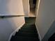 Carpeted stairway leading to the upper level of the home with white wall and railing at 2706 Club Cortile Cir, Kissimmee, FL 34746