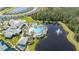 Aerial view of a community pool, clubhouse, and recreational amenities by a pond at 2719 River Creek Ln, St Cloud, FL 34771