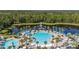 Aerial view of a community pool, amenity center, and lake surrounded by lush landscaping at 2719 River Creek Ln, St Cloud, FL 34771