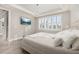 Bright bedroom featuring a tray ceiling, TV, shuttered windows, and access to the bathroom at 2719 River Creek Ln, St Cloud, FL 34771