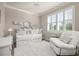 Cozy bedroom showcasing a daybed with many pillows, a white recliner, and a large window at 2719 River Creek Ln, St Cloud, FL 34771