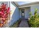 Close-up of the front door with a wreath, complemented by vibrant landscaping and a welcoming walkway at 2719 River Creek Ln, St Cloud, FL 34771