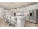 Bright kitchen with stainless steel refrigerator, white cabinets, and large island with barstool seating at 2719 River Creek Ln, St Cloud, FL 34771