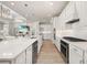 Open-concept kitchen featuring stainless appliances, white cabinetry, and an expansive island with seating at 2719 River Creek Ln, St Cloud, FL 34771