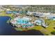 Aerial view of community pool and clubhouse with tennis courts, beach umbrellas and sun loungers at 2719 River Creek Ln, St Cloud, FL 34771