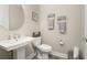 Neutral-toned powder room featuring a pedestal sink, decorative mirror, and stylish accents at 2719 River Creek Ln, St Cloud, FL 34771