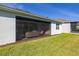 A well-lit, furnished screened porch overlooks a manicured lawn at 2719 River Creek Ln, St Cloud, FL 34771