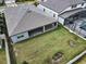 Aerial view of the home's backyard, showing covered patio, green grass, and screened in pool area at 2768 Matera Dr, St Cloud, FL 34771
