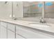 Bathroom with dual sinks, white cabinets, chrome faucets, and a large mirror reflecting the shower at 2768 Matera Dr, St Cloud, FL 34771