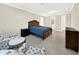 Spacious bedroom with tile floors features a wooden bed frame and a sitting area with patterned chairs at 2768 Matera Dr, St Cloud, FL 34771