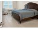 Cozy bedroom features a wooden bed frame, tile floors, window and a sitting area at 2768 Matera Dr, St Cloud, FL 34771