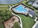 Aerial view of the community pool and playground area near a lake and walking trail at 2768 Matera Dr, St Cloud, FL 34771