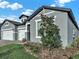 Charming exterior with grey stucco, white trim, and a well-maintained lawn, enhancing the curb appeal at 2768 Matera Dr, St Cloud, FL 34771