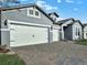 Three-car garage with white doors and brick-paved driveway, adding to the home's curb appeal at 2768 Matera Dr, St Cloud, FL 34771