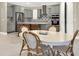 Bright eat-in kitchen boasts stainless steel appliances, grey cabinets, patterned backsplash, and an island with seating at 2768 Matera Dr, St Cloud, FL 34771