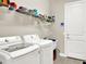 Bright laundry room featuring modern appliances and storage shelves at 2768 Matera Dr, St Cloud, FL 34771