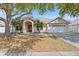 Inviting single-story home with a red front door, well-kept lawn, and beautiful shade trees at 2804 Latter Day Ct, St Cloud, FL 34769