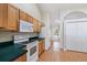 Bright kitchen featuring wood cabinets, white appliances, and tile flooring, offering plenty of storage and counter space at 2804 Latter Day Ct, St Cloud, FL 34769