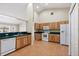 Bright kitchen featuring wood cabinets, white appliances, and tile flooring, creating a functional and inviting space at 2804 Latter Day Ct, St Cloud, FL 34769