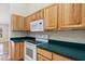 Bright kitchen featuring wood cabinets and white appliances providing a functional cooking space at 2804 Latter Day Ct, St Cloud, FL 34769