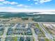 Scenic aerial view of a residential neighborhood with neatly arranged homes, green spaces, and a natural backdrop at 3005 Crispin Cir, Harmony, FL 34773