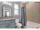 Bathroom featuring granite countertops, blue cabinets, bathtub with tiled wall and shower curtain at 3005 Crispin Cir, Harmony, FL 34773