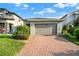 Beautiful one-story home featuring a brick driveway, manicured lawn, and attached two-car garage at 3005 Crispin Cir, Harmony, FL 34773