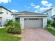 Charming single-Gathering home with a brick driveway, gray exterior, and lush landscaping at 3005 Crispin Cir, Harmony, FL 34773