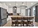 Elegant kitchen featuring white cabinets, a large island, modern appliances, and stylish pendant lights at 3005 Crispin Cir, Harmony, FL 34773